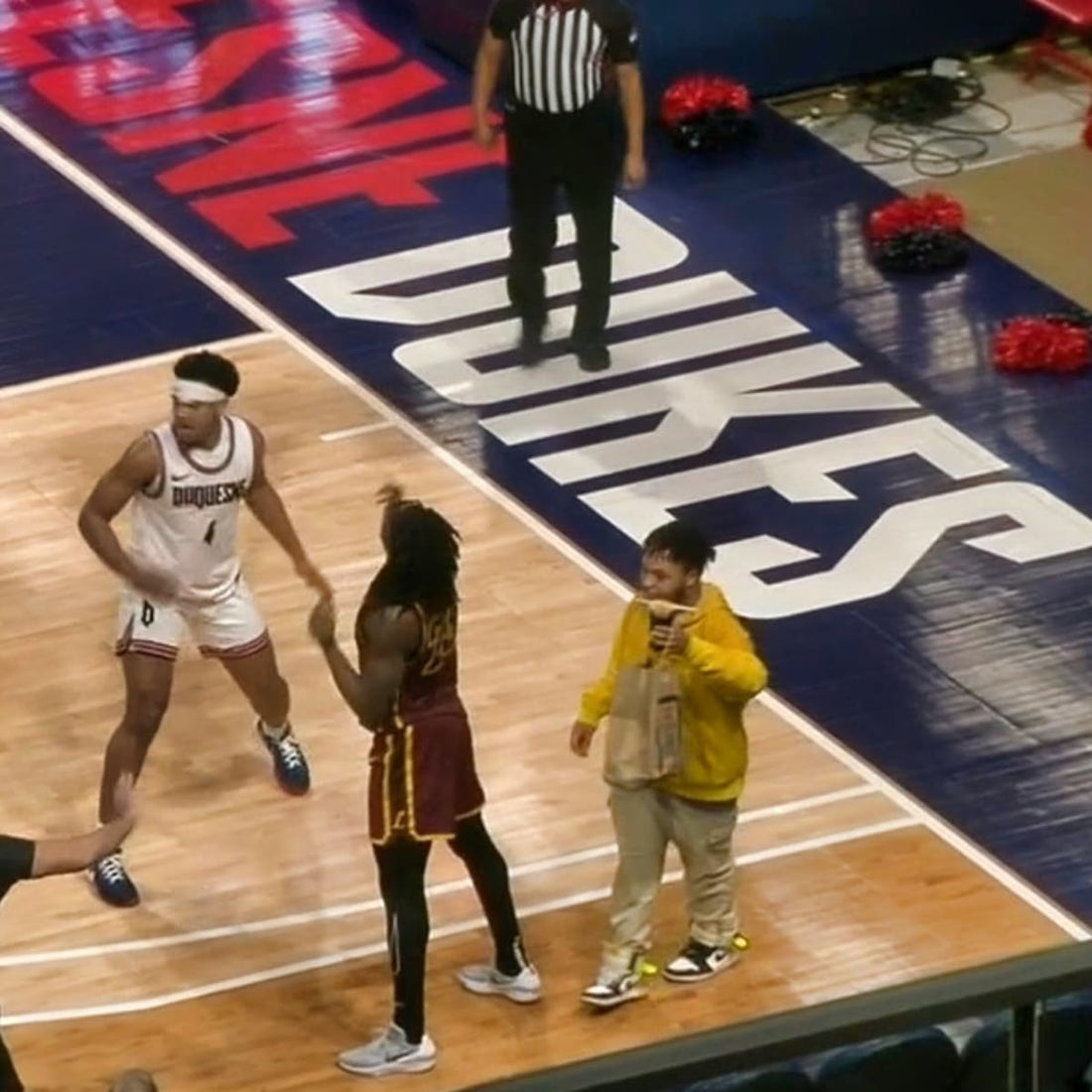 Uber Eats driver walks on court during college basketball game